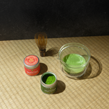 Samidori and Uji Hikari matcha tins next to each other with brewed match and a chasen