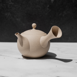 Speckled tea pot on a white surface