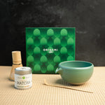 Mizuba Matcha tin next to a chasen, chawan, and matcha bowl