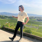 Woman stands in front of a Japanese tea field wearing a cream colored Mizuba Tea Co shirt